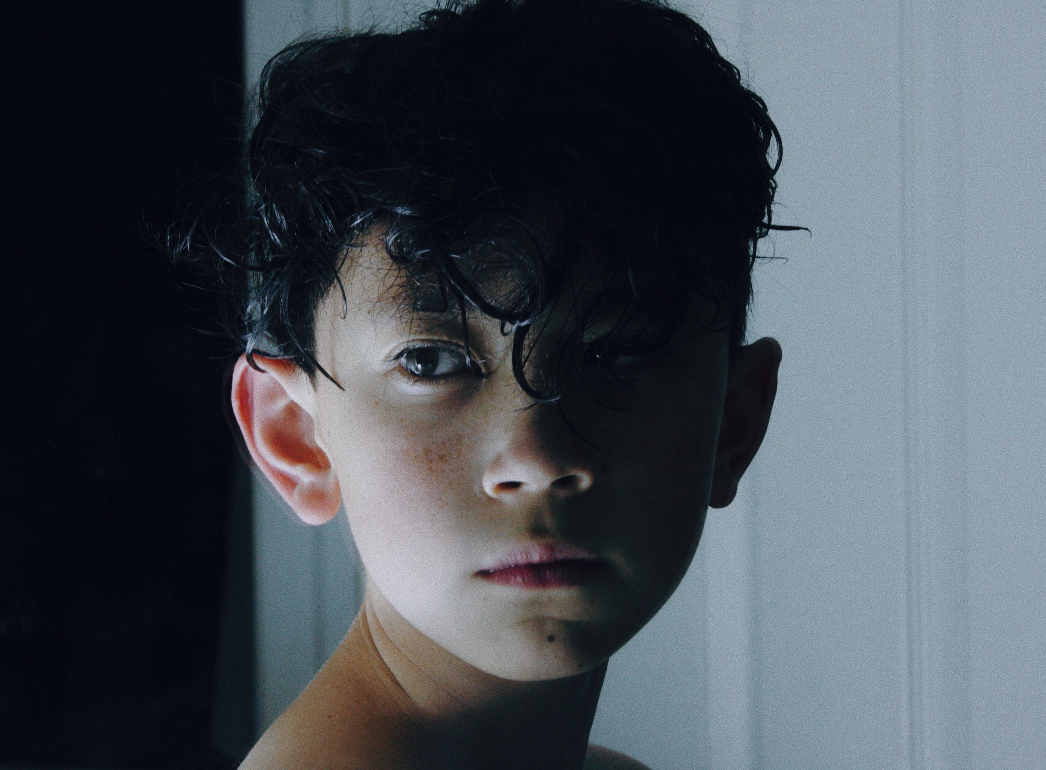 A young person looks over their shoulder in an indoor space. 