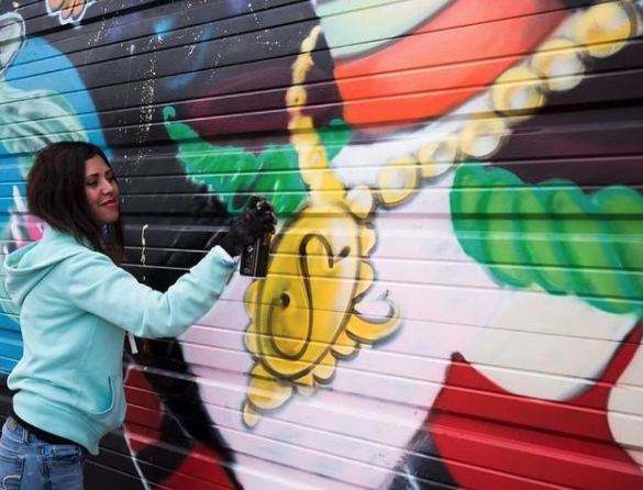 Photo of the artist with a spray paint can in hand