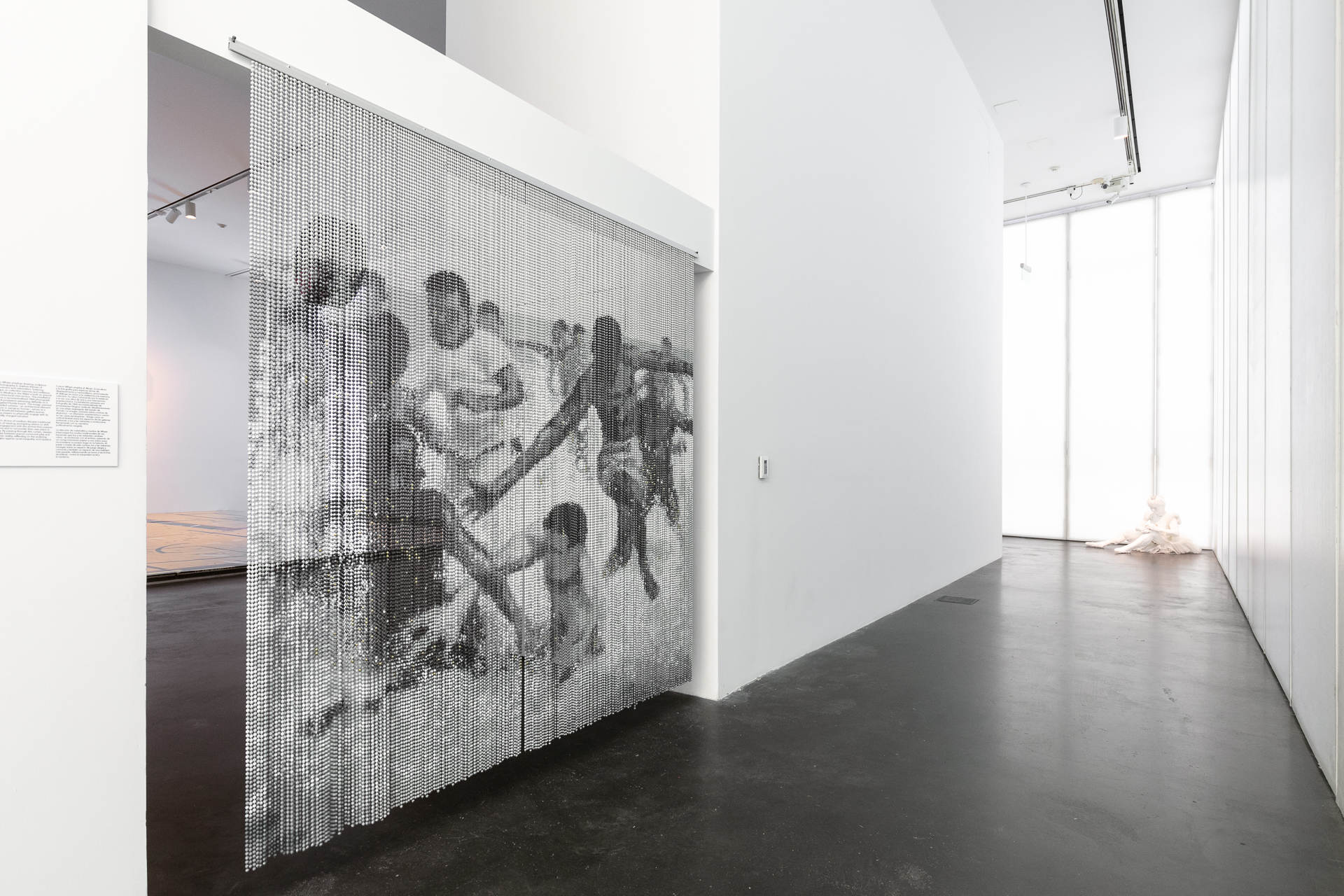 Black and white beaded curtains depicting a photograph of Black protestors swimming defiantly on a segregated beach.