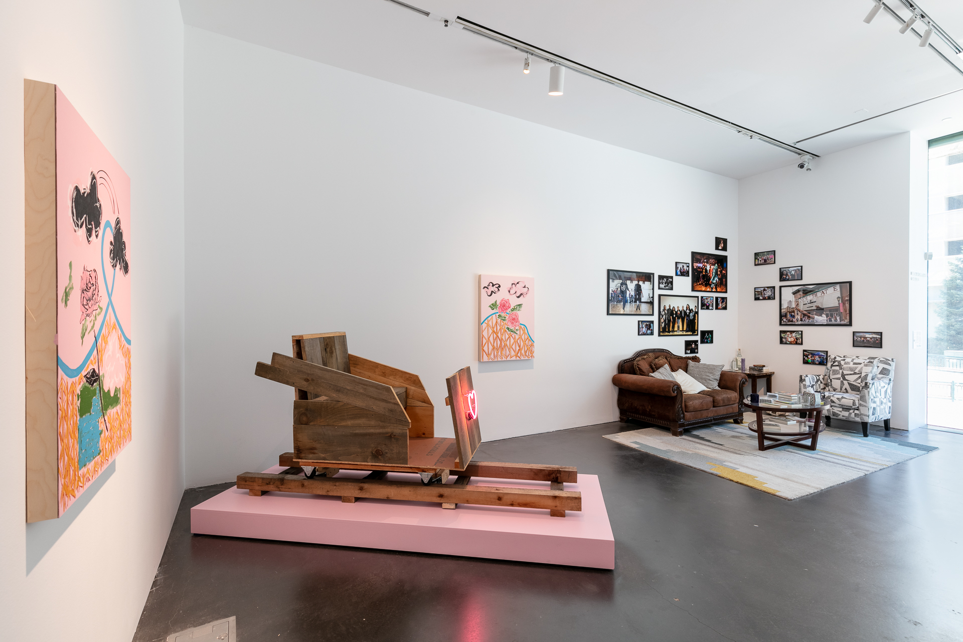 Gallery featuring a wooden roller coaster seat and what looks like a living room setup with a couch, chair, and coffee table.