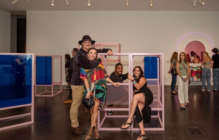 Group of people smiling in an art gallery.